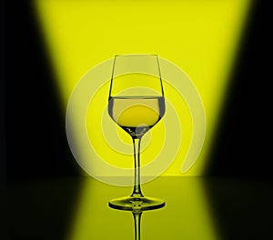Wineglass with white wine on multicolored background