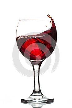 Wineglass with wine red juice beverage splashing wave and ice cube isolated on white background full size