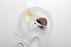 Wineglasses with red, white wine lying with stems crossed.