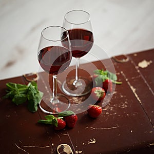 Wineglasses with red wine decorated with strawberry and mint