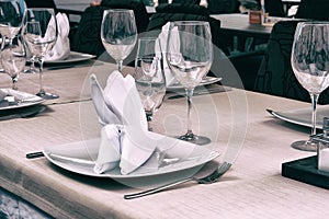 Wineglasses served for a festive dinner. Table setting in restaurant. Decorated holiday table