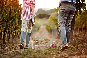 Winegrower couple in vineyard tasting wine