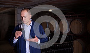 Winemaker checking red wine in wine cellar