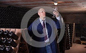 Winemaker degusting red wine in wine cellar