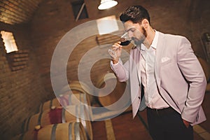 Winemaker inspecting wine in basement