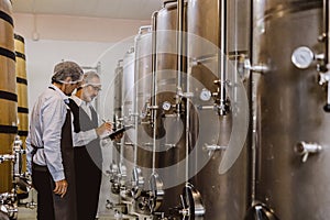 Winemaker professional working in modern large winery factory liquor alcohol drinks industry quality control and fermentation