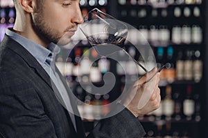 Winemaker sommelier man sniffing aroma red wine in glass