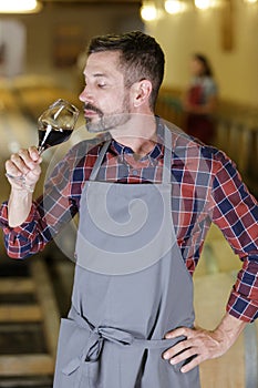 Winemaker tasting red wine in cellar