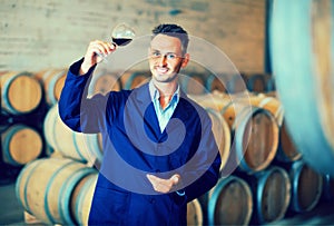 Winery expert wearing coat holding glass of wine
