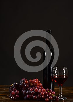 Winetasting and degustation still life concept. Grapes, bottle and wineglass photo