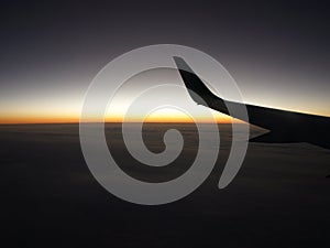 Wing of aircraft flying at dawn