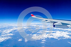 Wing of an aircraft flying far above the cloud cover