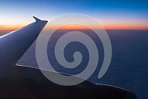 Wing of airplane above clouds