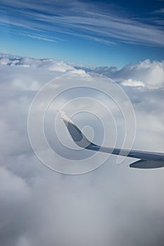 Wing of airplane above clouds