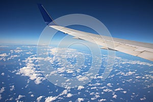 Wing of airplane above white clouds