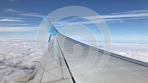 Wing of airplane, fly above clouds, blue sky