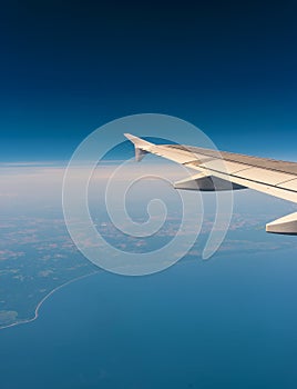 Wing of an airplane flying above the clouds