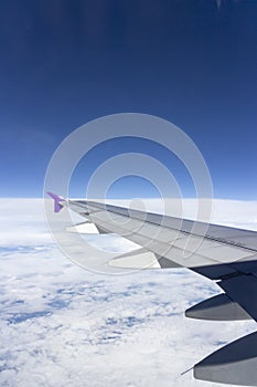 Wing of an airplane flying above the clouds