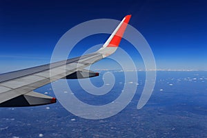 Wing of an airplane flying above the clouds