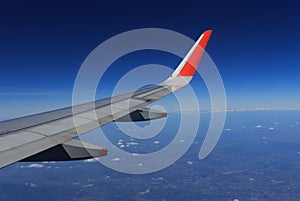 Wing of an airplane flying above the clouds