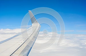 Wing of an airplane flying above the clouds