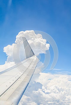 Wing of an airplane flying above the clouds