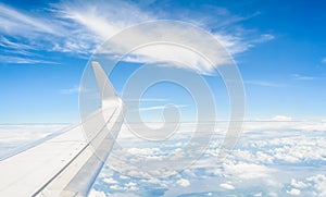 Wing of an airplane flying above the clouds