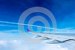 Wing of an airplane flying above the clouds