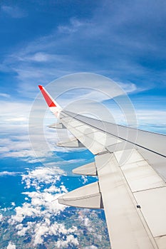 Wing of an airplane flying above the clouds people look at the s