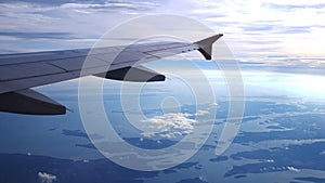 Wing of an airplane flying above the clouds with sunset sky. Aircraft.