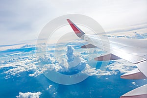 Wing of an airplane flying above the clouds view