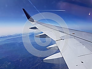 Wing of an airplane flying above the morning clouds plane wing airplane Wing of an airplane flying above the clouds. people looks