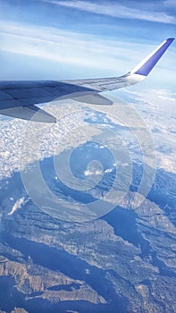 the wing of an airplane flying over a mountain range