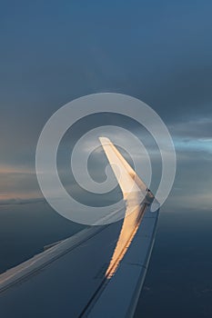 Wing of airplane with sunlight on winglet