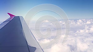 Wing airplane on white clouds and blue sky landscape. View from window flying in blue sky with white clouds. Cloudy