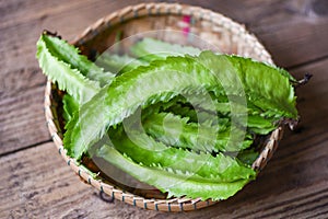 Wing bean on basket and wooden table background, young winged beans vegetable