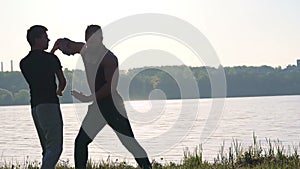 Wing Chun performance near the river between strong men. Slowly