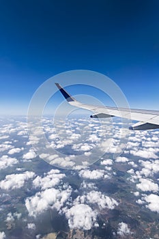 Wing of a Flying Airplane above clouds over Chennai