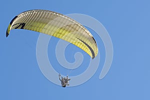 The wing of paraplan against a blue sky. Two paragliderists are flying in tandem. Copy space