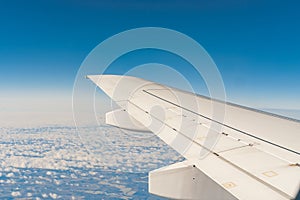 Wing of passsanger plane above the land, view from inside