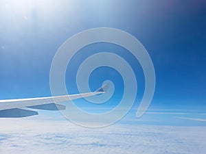 Wing of the plane on blue sky background with morning sun light