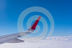 Wing of plane with blue sky and cloud