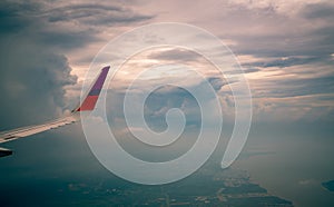 Wing of plane over the city. Airplane flying on blue sky. Scenic view from airplane window. Commercial airline flight