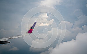 Wing of plane over the city. Airplane flying on blue sky. Scenic view from airplane window. Commercial airline flight