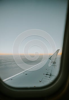 Wing view from an airplane window in the sunrise