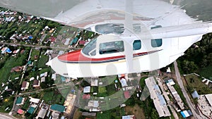 Wing view of a small four-seater airplane during flight.