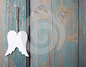 Wings of angel hanging on wooden background