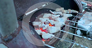 Wings strung on skewers are prepared in a barbecue