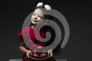 Winked eye girl with pomegranates basket in front of her photo