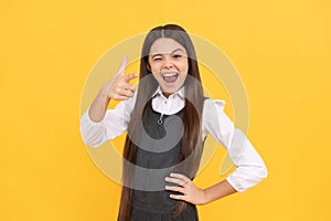 Winking school age girl child happy smile pointing finger gun hand gesture, September 1